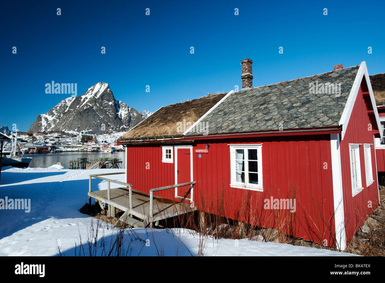 Traditional red wooden Rorbu fisherman`s hut in village of Reine in Lofoten Islands in Norway Stock Photo